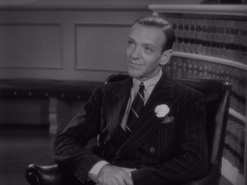 Movie still from “Carefree” (1938), directed by Mark Sandrich – A black - and - white photo of a man sitting in a chair; Close Up shot, High angle