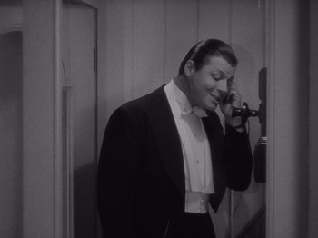 Movie still from “Carefree” (1938), directed by Mark Sandrich – A man talking on a phone while wearing a tuxedo; Medium shot, High angle