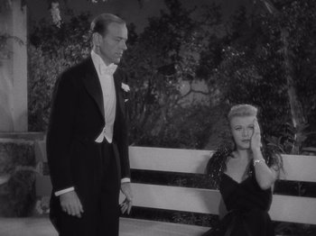 Movie still from “Carefree” (1938), directed by Mark Sandrich – A man and a woman standing next to each other on a park bench; Medium shot, High angle