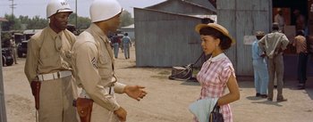 Movie still from “Carmen Jones” (1954), directed by Otto Preminger – An old photo of a man and a woman talking to each other; Medium shot, Over the shoulder angle