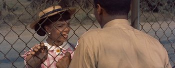 Movie still from “Carmen Jones” (1954), directed by Otto Preminger – A man and a woman are standing next to a fence; Close Up shot, Over the shoulder angle