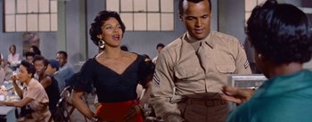 Movie still from “Carmen Jones” (1954), directed by Otto Preminger – A man and a woman are standing in a room together; Medium shot, Low angle