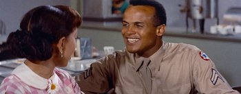 Movie still from “Carmen Jones” (1954), directed by Otto Preminger – An african american man sitting at a table with a woman; Close Up shot, Over the shoulder angle