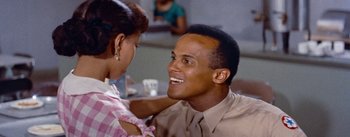 Movie still from “Carmen Jones” (1954), directed by Otto Preminger – A man and a woman are smiling at each other; Close Up shot, High angle