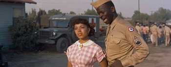Movie still from “Carmen Jones” (1954), directed by Otto Preminger – A woman and a man standing next to each other in front of an ambulance; Medium shot, Low angle