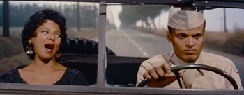 Movie still from “Carmen Jones” (1954), directed by Otto Preminger – A man sitting in the driver's seat of a car; Close Up shot, Low angle