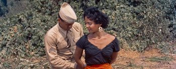 Movie still from “Carmen Jones” (1954), directed by Otto Preminger – A woman in a black top and a man in an army uniform; Medium shot, High angle