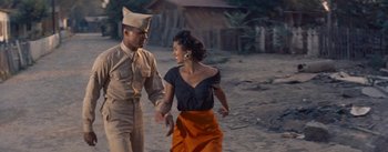 Movie still from “Carmen Jones” (1954), directed by Otto Preminger – A man and a woman holding hands while walking on the beach; Medium shot, Low angle