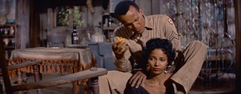 Movie still from “Carmen Jones” (1954), directed by Otto Preminger – A man and a woman sitting in front of each other; Medium shot, Over the shoulder angle