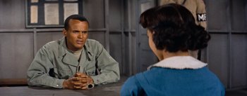 Movie still from “Carmen Jones” (1954), directed by Otto Preminger – A man and a woman are sitting at a table talking; Medium shot, Over the shoulder angle