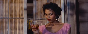 Movie still from “Carmen Jones” (1954), directed by Otto Preminger – A woman holding a glass of beer in her hand; Close Up shot, Over the shoulder angle