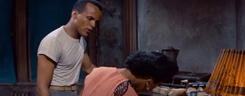 Movie still from “Carmen Jones” (1954), directed by Otto Preminger – A man and a woman are looking at a book; Medium shot, Over the shoulder angle