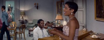 Movie still from “Carmen Jones” (1954), directed by Otto Preminger – A man and a woman are sitting at a table; Medium shot, Over the shoulder angle