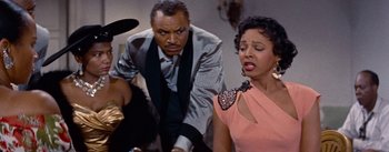 Movie still from “Carmen Jones” (1954), directed by Otto Preminger – A man and a woman sing in front of another man; Medium shot, Over the shoulder angle