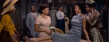 Movie still from “Carmen Jones” (1954), directed by Otto Preminger – A group of people standing in a room; Medium shot, Over the shoulder angle