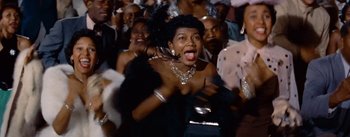 Movie still from “Carmen Jones” (1954), directed by Otto Preminger – A woman in a crowd of people wearing a black dress; Close Up shot, Low angle