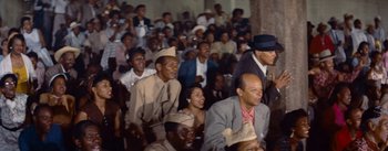 Movie still from “Carmen Jones” (1954), directed by Otto Preminger – A group of people sitting in a room; Medium shot, High angle