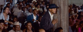 Movie still from “Carmen Jones” (1954), directed by Otto Preminger – A crowd of people sitting and standing in a room; Close Up shot, High angle