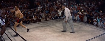 Movie still from “Carmen Jones” (1954), directed by Otto Preminger – A crowd of people in a boxing ring watching an event; Wide shot, High angle