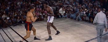 Movie still from “Carmen Jones” (1954), directed by Otto Preminger – Two boxers in a boxing ring in front of an audience; Wide shot, High angle
