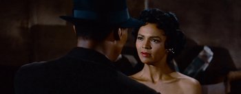 A man and a woman looking at one another in front of a mirror