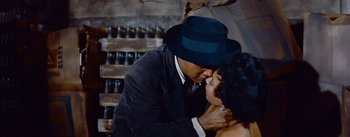 Movie still from “Carmen Jones” (1954), directed by Otto Preminger – A man and a woman kissing in front of a wine rack; Close Up shot, Low angle