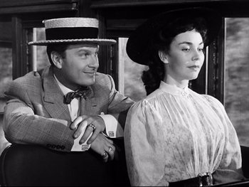 Movie still from “Carrie” (1952), directed by William Wyler – A man and a woman sitting next to each other on a train; Medium shot, Low angle