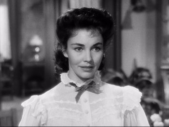 Movie still from “Carrie” (1952), directed by William Wyler – A black - and - white photo of a woman in a white dress; Close Up shot, Over the shoulder angle