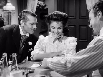 Movie still from “Carrie” (1952), directed by William Wyler – A man and a woman sitting at a table; Medium shot, Over the shoulder angle