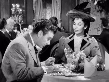 Movie still from “Carrie” (1952), directed by William Wyler – A man and a woman sitting at a dinner table; Medium shot, High angle