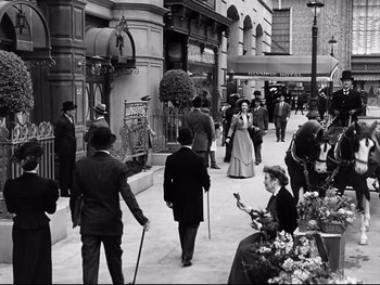 Movie still from “Carrie” (1952), directed by William Wyler – A black and white photo of people walking down a street; Wide shot, High angle