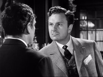 Movie still from “Carrie” (1952), directed by William Wyler – A man in a suit talking to another man in a suit; Close Up shot, Over the shoulder angle