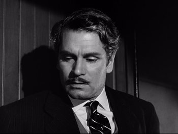 Movie still from “Carrie” (1952), directed by William Wyler – Black and white photograph of a man in a suit and tie; Close Up shot, High angle