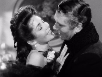 Movie still from “Carrie” (1952), directed by William Wyler – A man and a woman kissing each other in a black and white photo; Close Up shot, Low angle