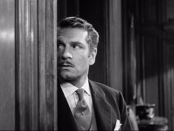 Movie still from “Carrie” (1952), directed by William Wyler – A black and white photo of a man in a suit and tie; Close Up shot, Low angle