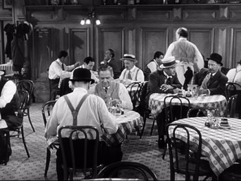 Movie still from “Carrie” (1952), directed by William Wyler – A black and white photo of people sitting at a table; Wide shot, High angle