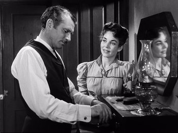 Movie still from “Carrie” (1952), directed by William Wyler – A man and a woman standing next to each other at a table; Medium shot, Over the shoulder angle