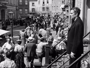 Movie still from “Carrie” (1952), directed by William Wyler – A crowd of people walking down a sidewalk; Wide shot, High angle