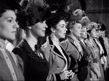 Movie still from “Carrie” (1952), directed by William Wyler – A group of women standing next to each other; Medium shot, Low angle