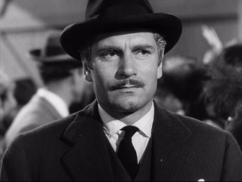 Movie still from “Carrie” (1952), directed by William Wyler – A man in a suit wearing a hat; Close Up shot, Low angle