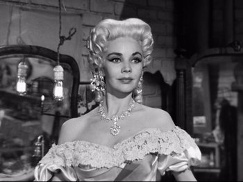 Movie still from “Carrie” (1952), directed by William Wyler – A black and white photo of a woman in a white dress; Close Up shot, Low angle