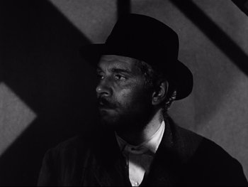 Movie still from “Carrie” (1952), directed by William Wyler – A man wearing a hat and a suit; Close Up shot, Low angle