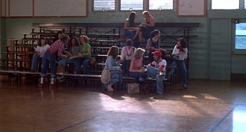 Movie still from “Carrie” (1976), directed by Brian De Palma – A group of people sitting on bleachers in a gym; Wide shot, High angle