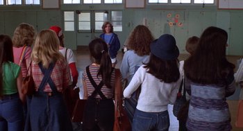 Movie still from “Carrie” (1976), directed by Brian De Palma – A group of people standing in front of a woman; Wide shot, High angle