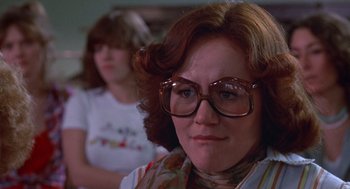 Movie still from “Carrie” (1976), directed by Brian De Palma – A person wearing glasses; Close Up shot, Over the shoulder angle