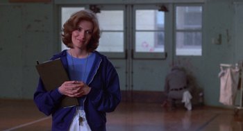 Movie still from “Carrie” (1976), directed by Brian De Palma – A woman standing in a room holding a clipboard; Medium shot, Over the shoulder angle