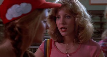 Movie still from “Carrie” (1976), directed by Brian De Palma – A woman in a pink shirt is talking to another woman in a red hat; Close Up shot, Over the shoulder angle