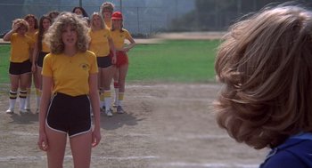 Movie still from “Carrie” (1976), directed by Brian De Palma – A group of women standing on top of a dirt field; Medium shot, Over the shoulder angle