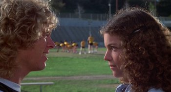Movie still from “Carrie” (1976), directed by Brian De Palma – Two girls are talking to each other on a field; Close Up shot, Over the shoulder angle