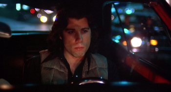 Movie still from “Carrie” (1976), directed by Brian De Palma – A man sitting in the back seat of a car at night; Close Up shot, Low angle